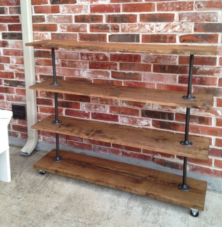 three wooden shelves against a brick wall