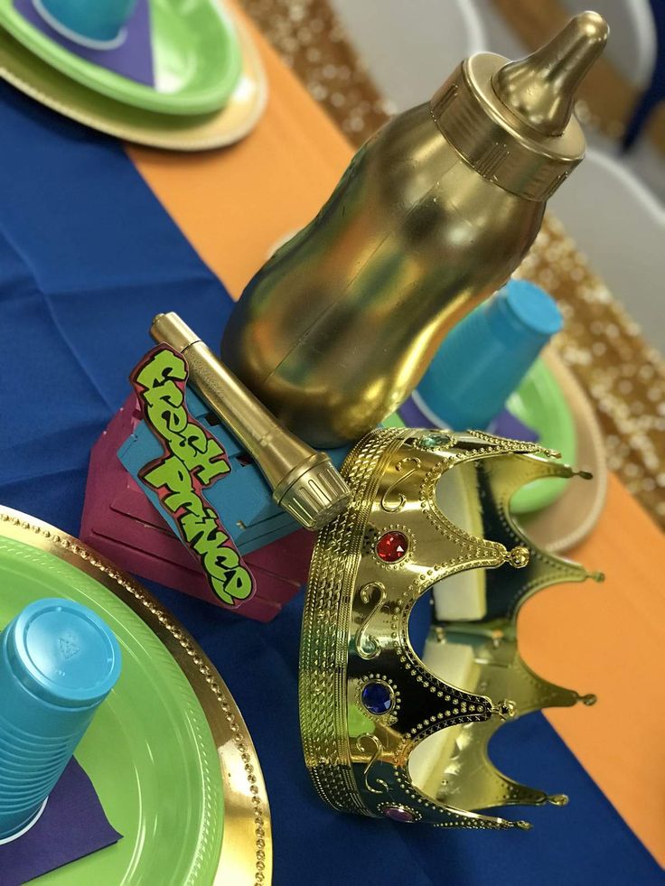 a table topped with plates and cups filled with candy bar containers next to a bottle