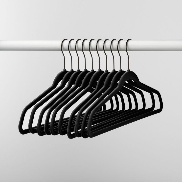 several black clothes hangers on a white rail