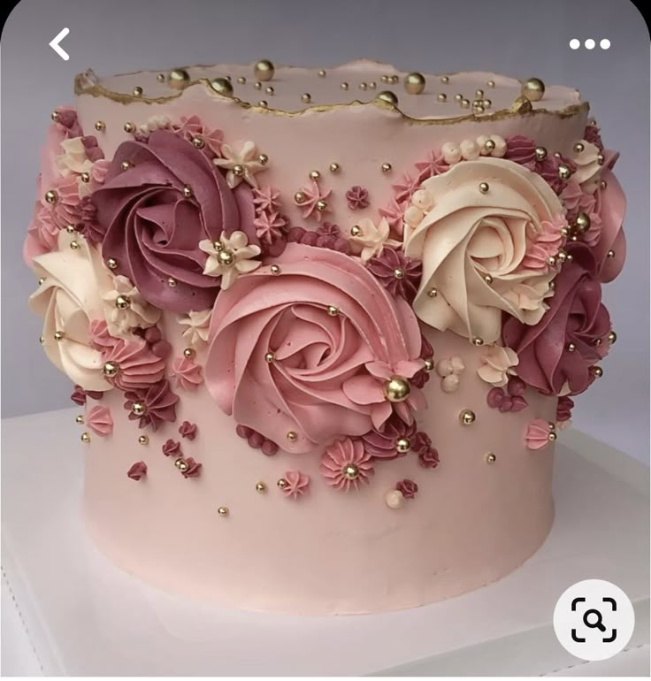 a pink cake decorated with flowers and pearls