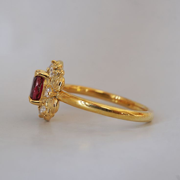 Indulge in timeless romance with the Rosaire spinel ring. Featuring a vibrant spinel center stone in a French-inspired setting, this ring captures and reflects light beautifully, reminiscent of Parisian nights. Crafted with delicate filigree, the Rosaire exudes elegance and vintage charm, making it the perfect symbol of eternal love. Ideal as a gift or a cherished addition to your collection, this stunning ring is a true treasure. All orders come in our Tippy Taste ring box. This ring is handmade and designed in NYC. 14K or 18K solid gold Natural oval red spinel, 5*4mm 12 Natural round diamonds. SI clarity, GH color, 0.1ct total carat weight 1.5mm ring band ** Tippy Taste Heirloom Collection is made to order. Please allow 3-4 week turnaround time. Shipping:Domestic: Free shippingInternatio Gold Gemstone Cluster Ring For Proposal, Elegant Tourmaline Sapphire Ring For Wedding, Gold Ruby Ring With Rose Cut Diamonds, Timeless Ruby Ring With Rose Cut Diamonds For Wedding, Elegant Gold Sapphire Ring With Halo Design, Elegant Gold Ruby Ring With Rose Cut Diamonds, Heirloom Yellow Gold Sapphire Ring With Halo, Elegant Tourmaline Sapphire Wedding Ring, Elegant Ruby Wedding Ring With Halo