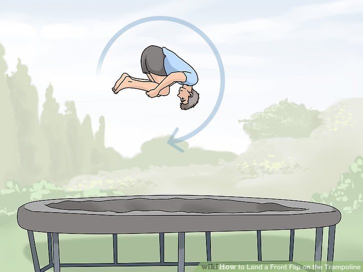 a man jumping off a trampoline into the air with his head in the air