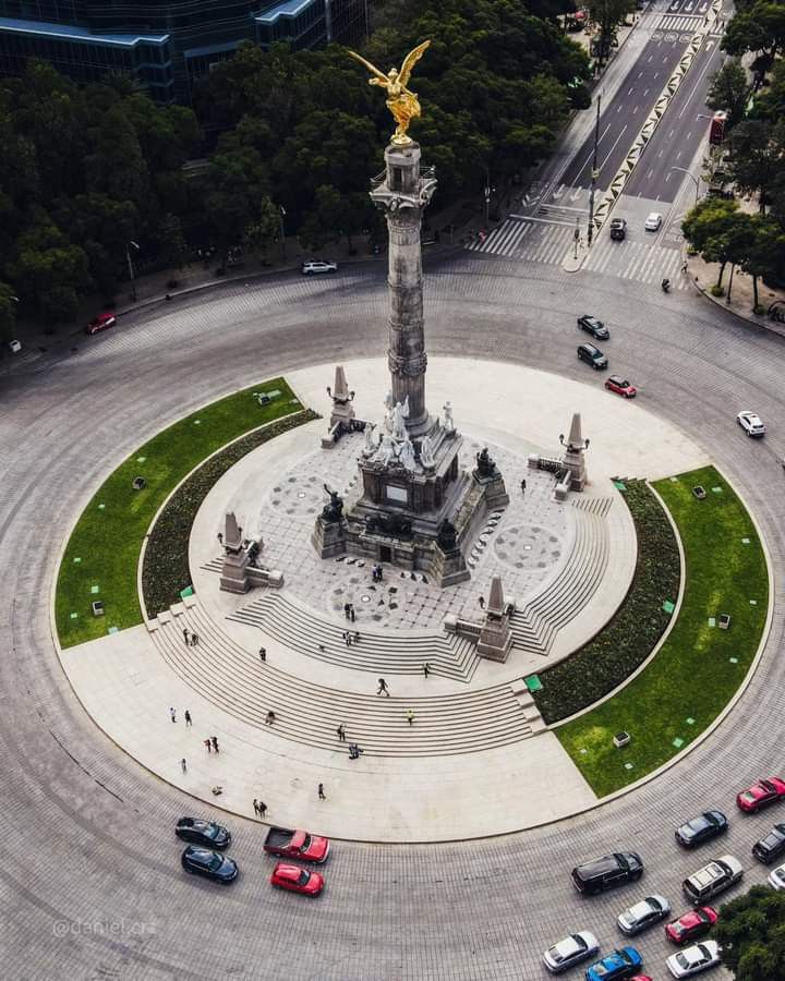 an aerial view of a monument in the middle of a circle with cars parked around it