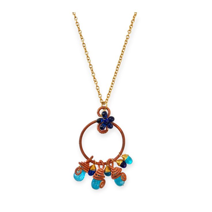 This one of a kind blue beaded cluster pendant necklace is a unique piece of jewelry that stands out with its colorful blue hued gemstones and clever contrast with copper and brass. The circular pendant made with copper is suspended from a brass metal chain necklace with a lobster clasp. The pendant has six blue tear shaped beads of alternating blues from teal to rich navy blue suspended from the hoop and at the top where the pendant hands from the chain sits a cluster of small dark blue beads. Blue Copper Pendant Necklace, Blue Beaded Brass Necklaces, Blue Pendant Necklace With Copper Wire, Blue Copper Wire Wrapped Necklaces, Blue Copper Wire Pendant Necklace, Blue Copper Wire Wrapped Necklace, Artisan Blue Metal Necklace, Bohemian Blue Copper Necklaces, Blue Copper Artisan Necklace