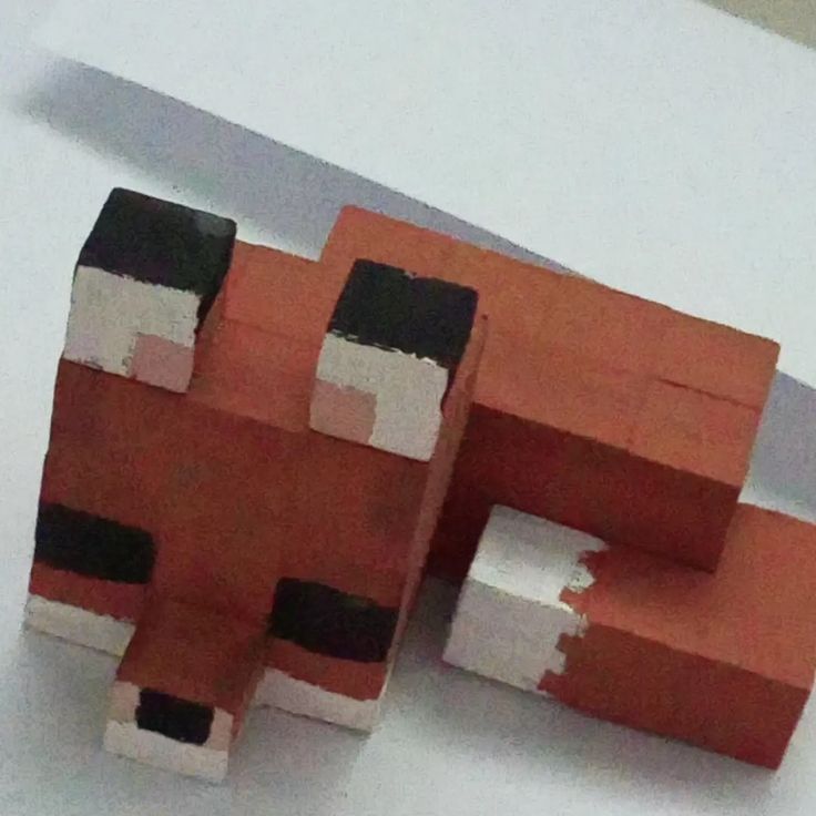 an orange and black block with white stripes on it's face, sitting next to a knife