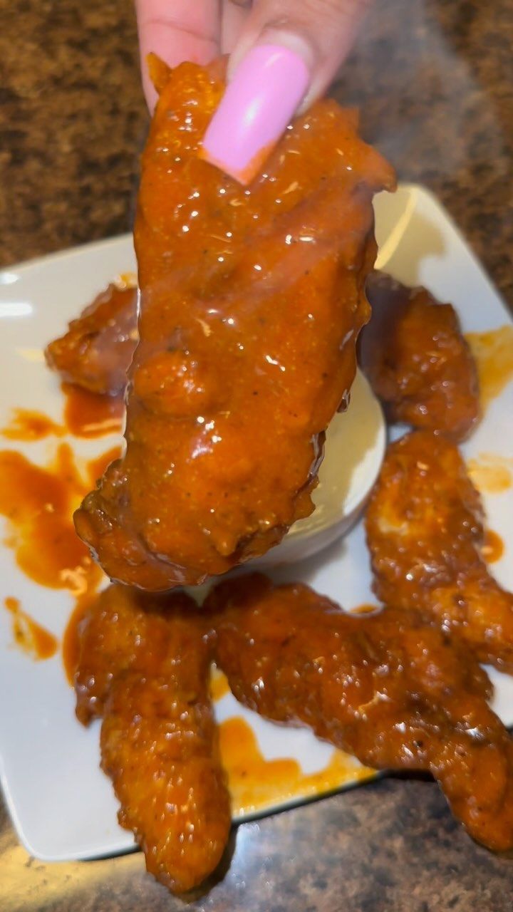 a person is dipping sauce on some kind of meat item with toothpicks in it