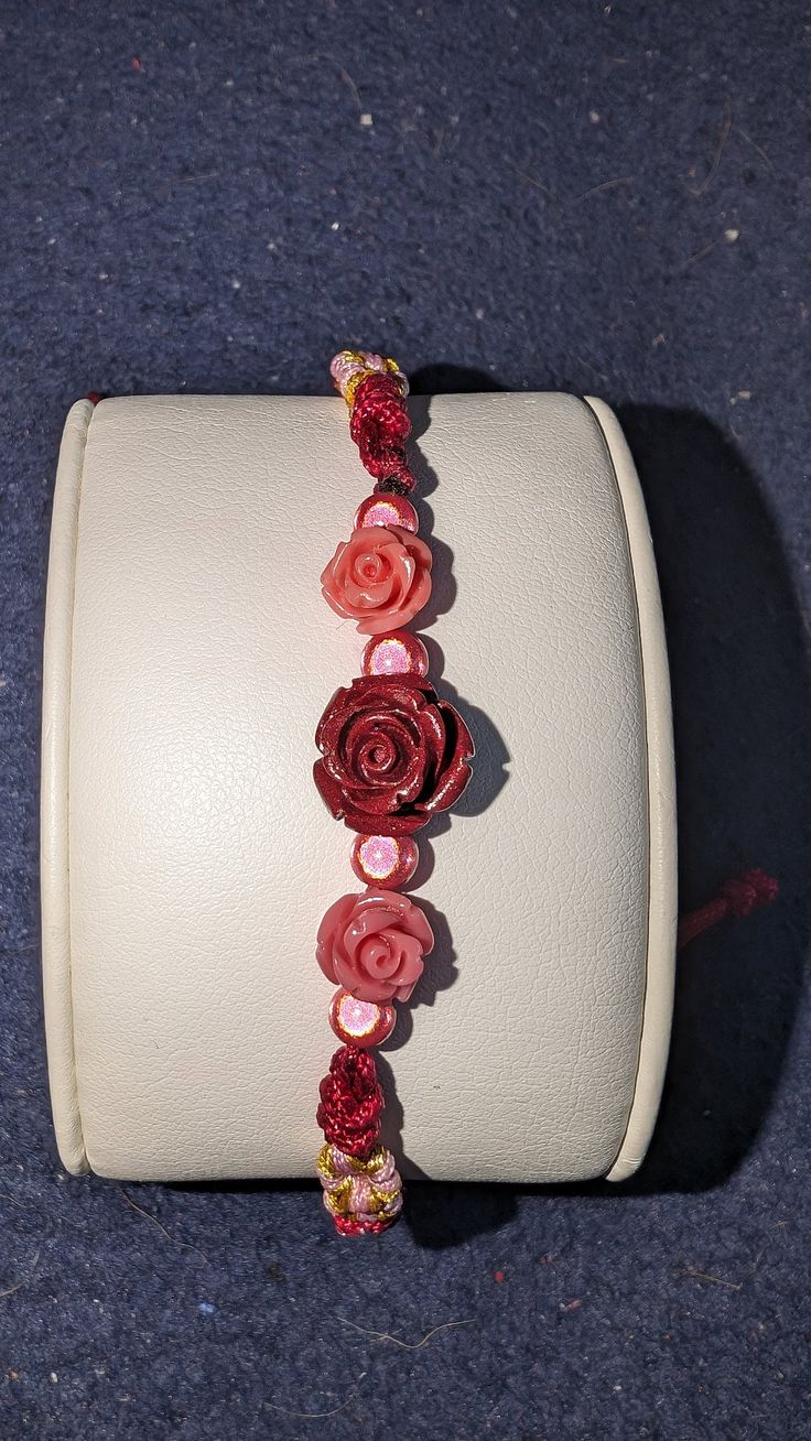 red shell rose with 3d beads and 2 pink shell rose on a red hand made bracelet. for the rose in your life Red Flower Shaped Bracelets For Gifts, Red Flower-shaped Handmade Bracelets, Handmade Red Flower Bracelet, Handmade Red Flower Bracelets, Adjustable Red Flower Beaded Bracelet, Adjustable Rose Red Flower Jewelry, Red Flower Bracelets For Valentine's Day, Adjustable Rose Bracelet For Gift, Adjustable Rose Bracelet (gift)