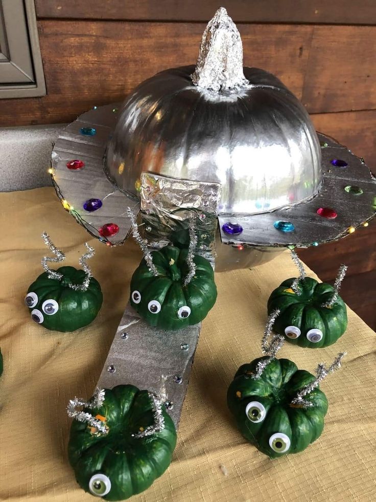 some green peppers with googly eyes on them and a silver platter filled with candy