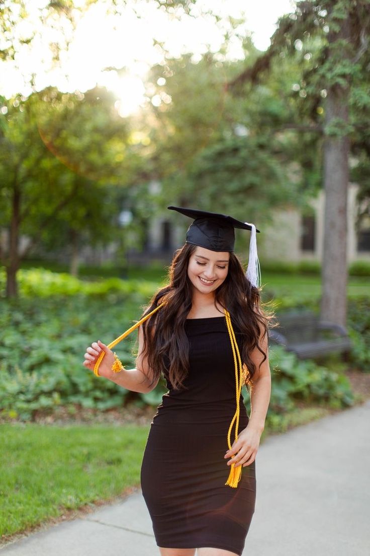 a woman in a graduation cap and gown is walking down the street with her diploma