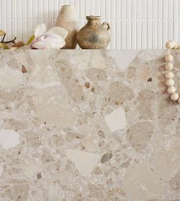 a marble counter top with white flowers and beads on the shelf next to each other