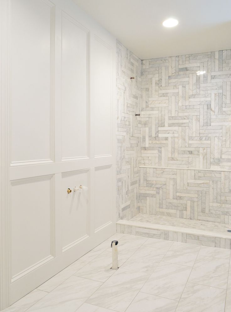 a bathroom with white walls and tile flooring next to a walk - in shower