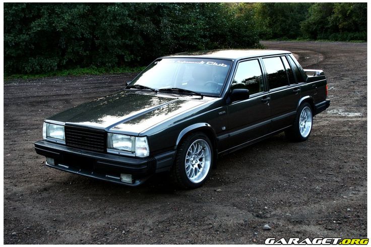 a black car parked on top of a dirt field