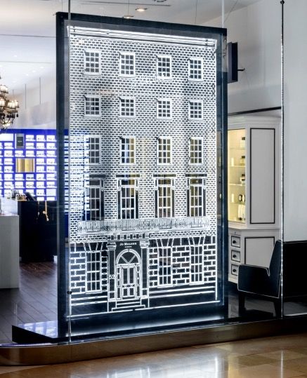 a tall building is seen through a glass door in an office space with a chandelier hanging from the ceiling