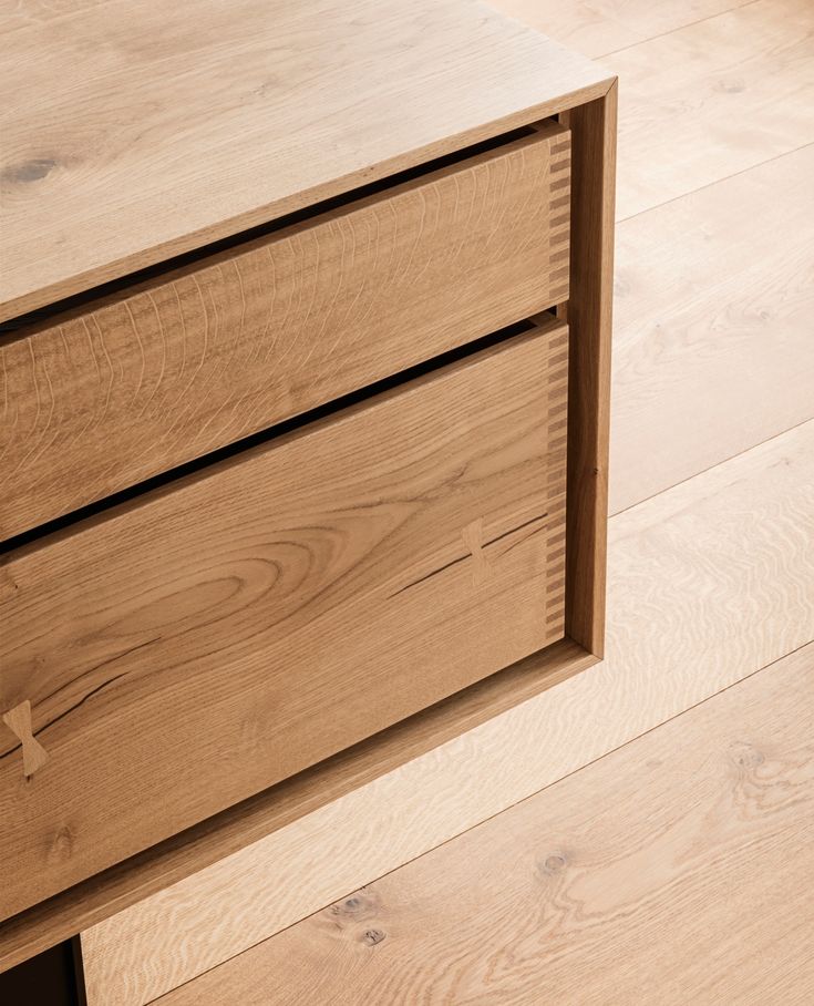 a close up of a drawer on a wooden floor with hard wood grained floors