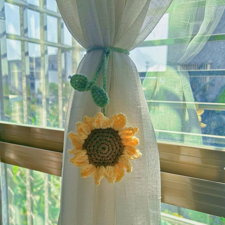 the sunflower is hanging from the curtain