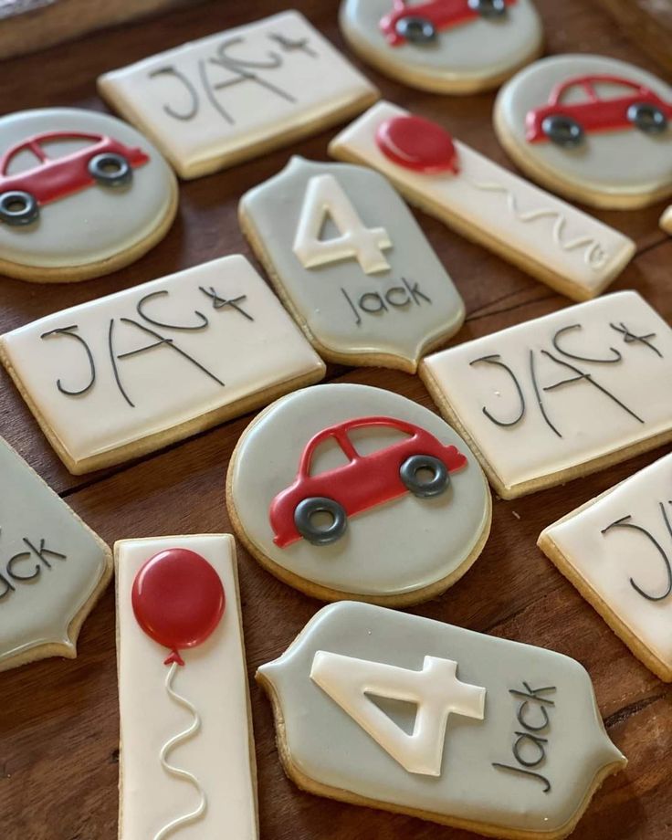 decorated cookies with numbers and cars are on a wooden table, ready to be eaten