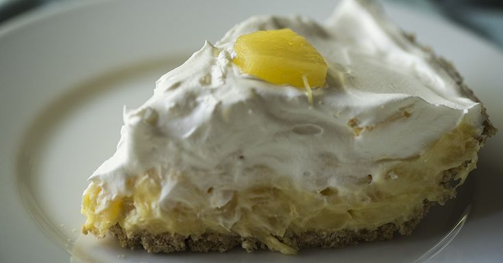 a piece of cake on a plate with white frosting and yellow candy in the middle