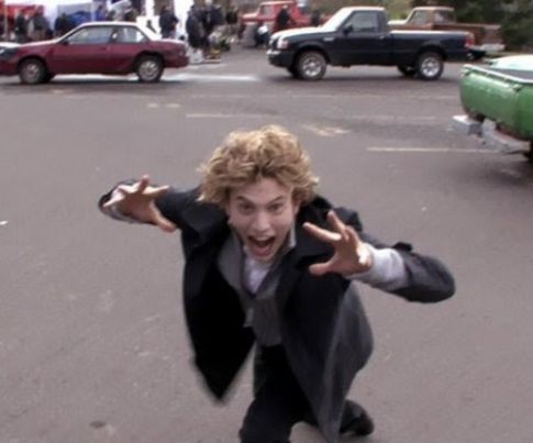 a young man riding a skateboard across a parking lot