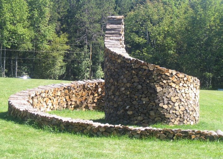 a large pile of logs sitting in the middle of a field