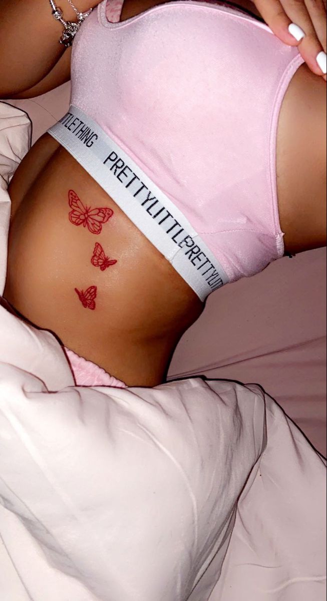 a woman laying in bed with her stomach covered by a tape that says pretty little butterflies