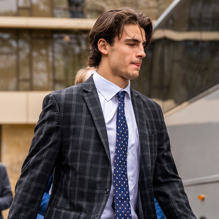 a man in a suit and tie walking down the street