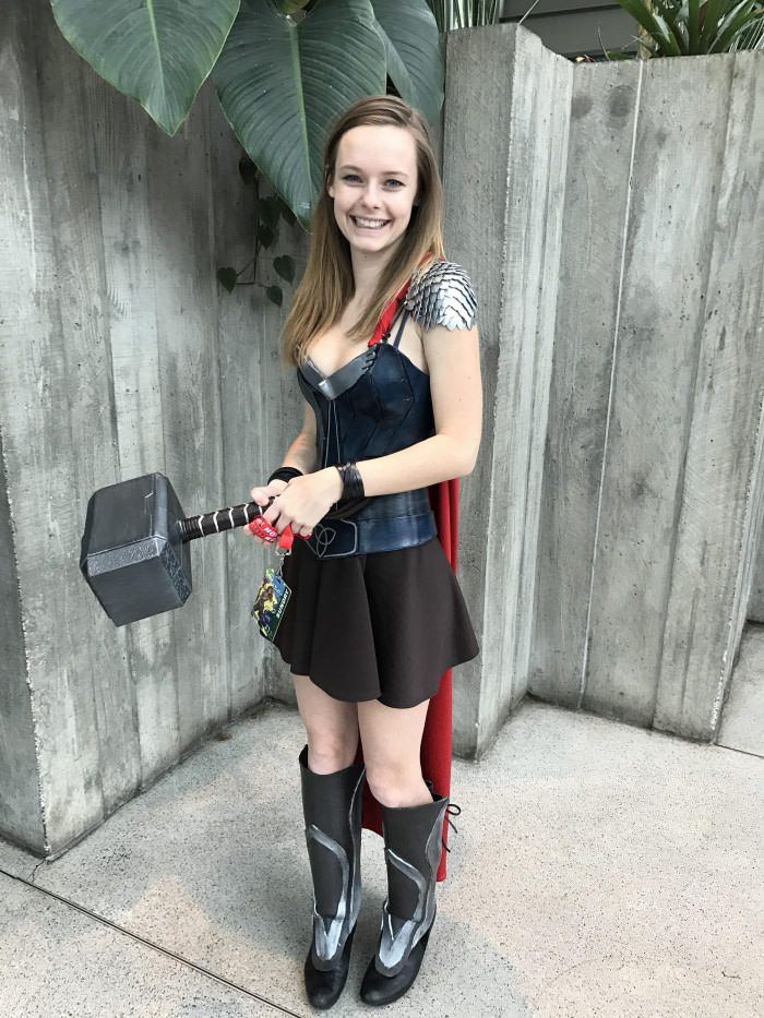 a girl dressed up as thor and holding a hammer