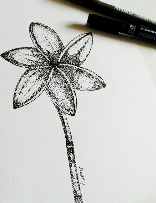 a pencil drawing of a flower on top of a piece of paper next to a marker