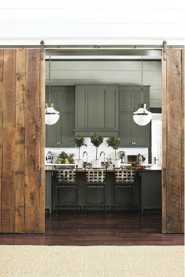 an open door leading to a kitchen with green cabinets