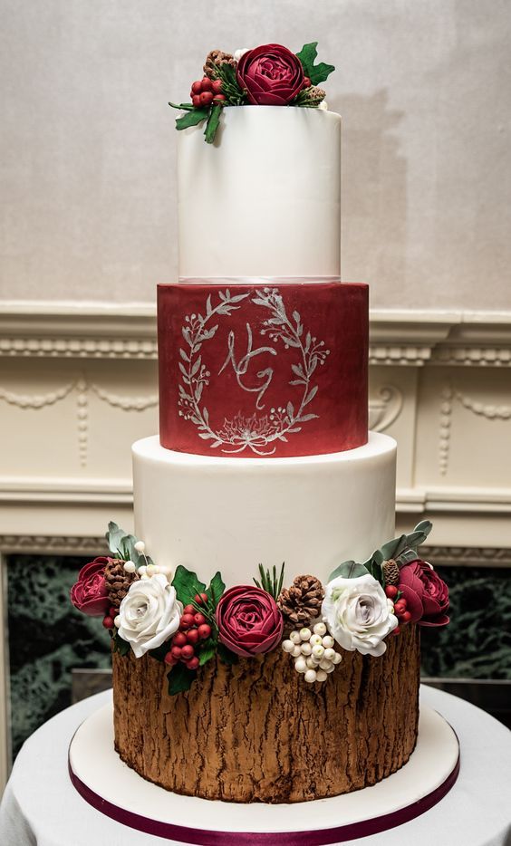 a three tiered wedding cake with red and white frosting on the top layer