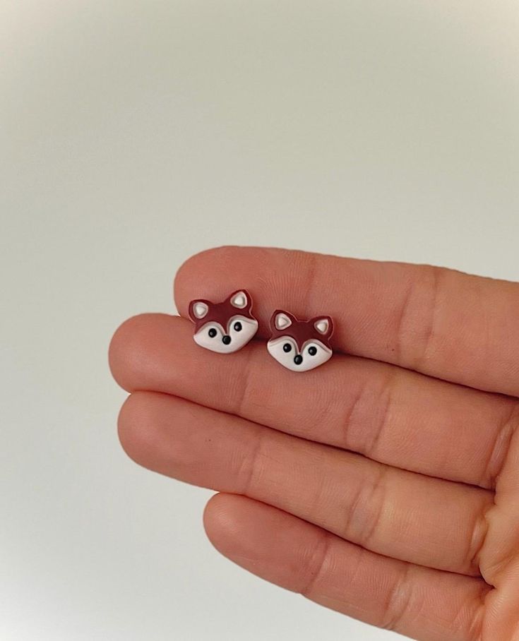 the tiny animal earrings have been made to look like they're wearing foxes on their ears