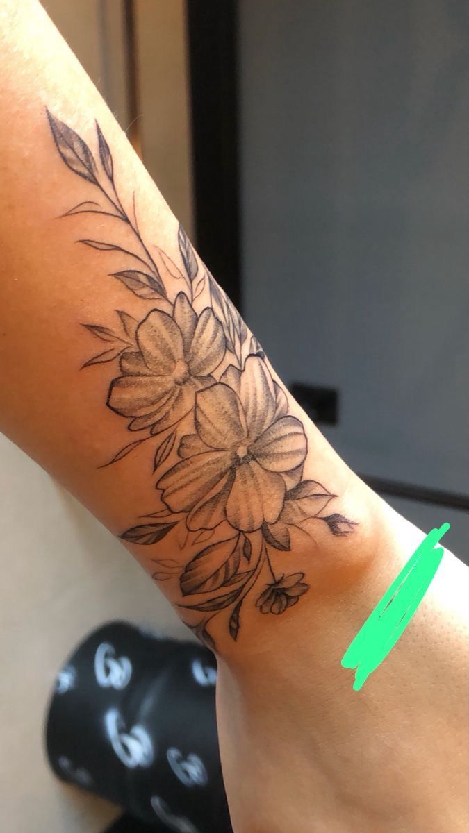 a woman's arm with a flower tattoo on it