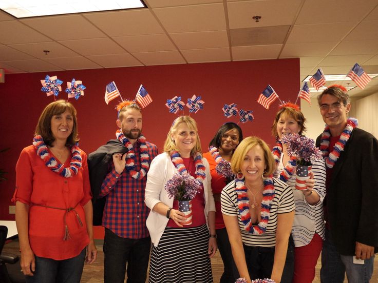 a group of people standing next to each other in front of a red white and blue wall