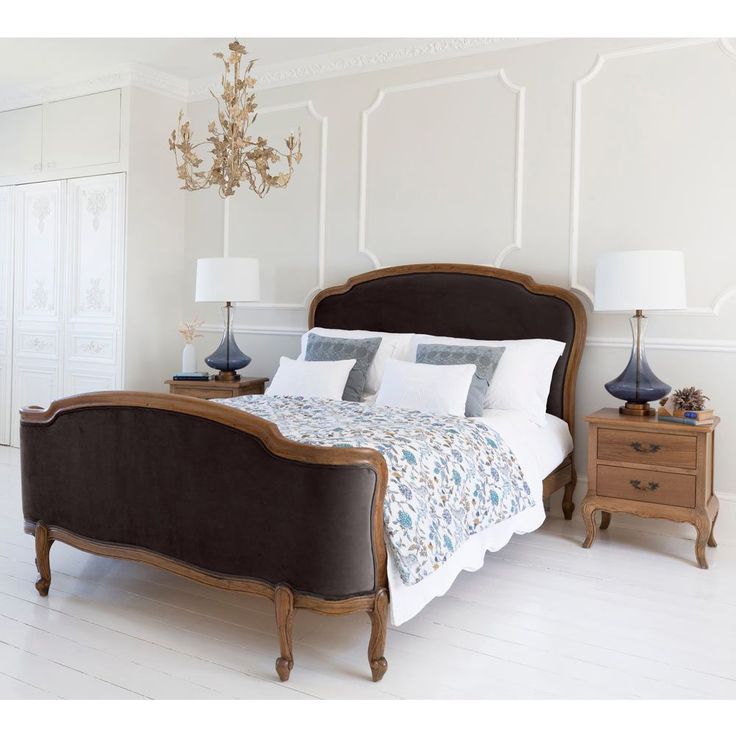 a bedroom with a bed, two nightstands and a chandelier