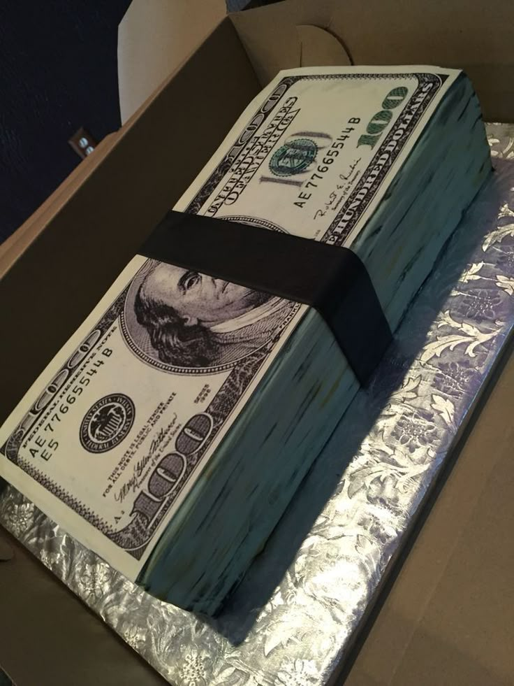 a cake made to look like one dollar bill in a box with foil on top