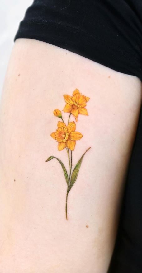 a yellow flower tattoo on the left thigh