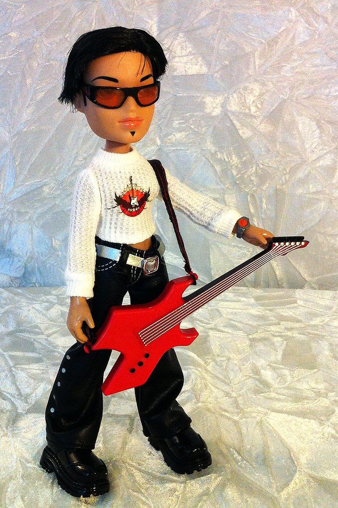 a doll holding a red guitar and wearing sunglasses