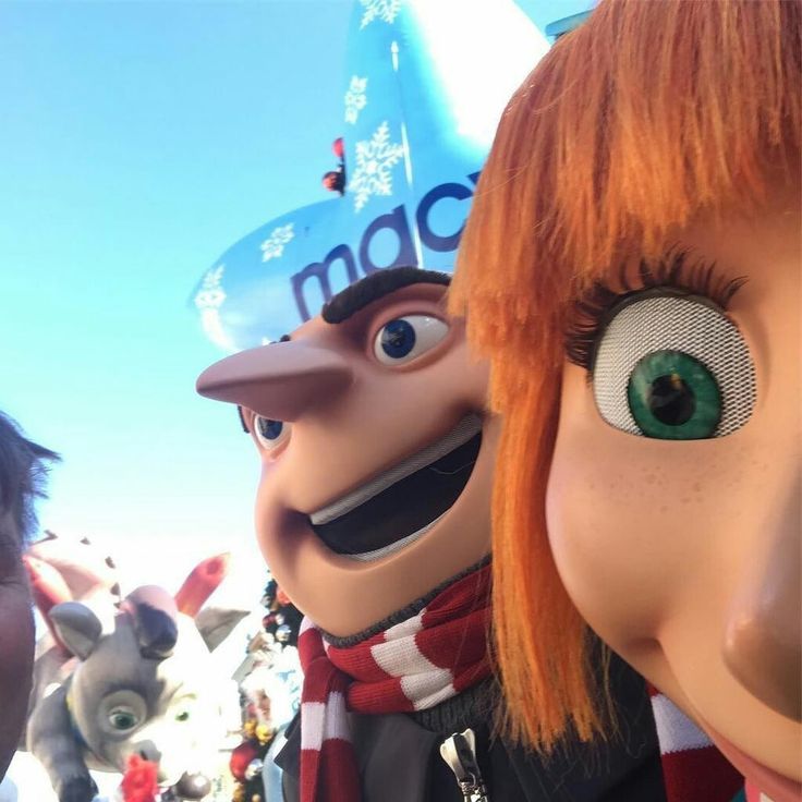 an animated character with red hair and green eyes standing next to another character wearing a scarf