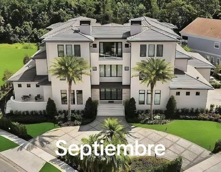 an aerial view of a large house with palm trees