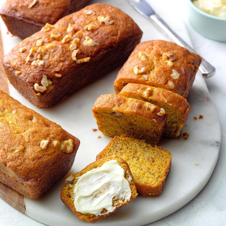 several pieces of bread on a plate with butter and other food items around the edge