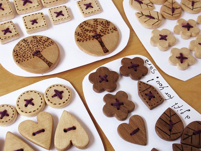 some wooden buttons and magnets sitting on a table next to paper plates with hearts