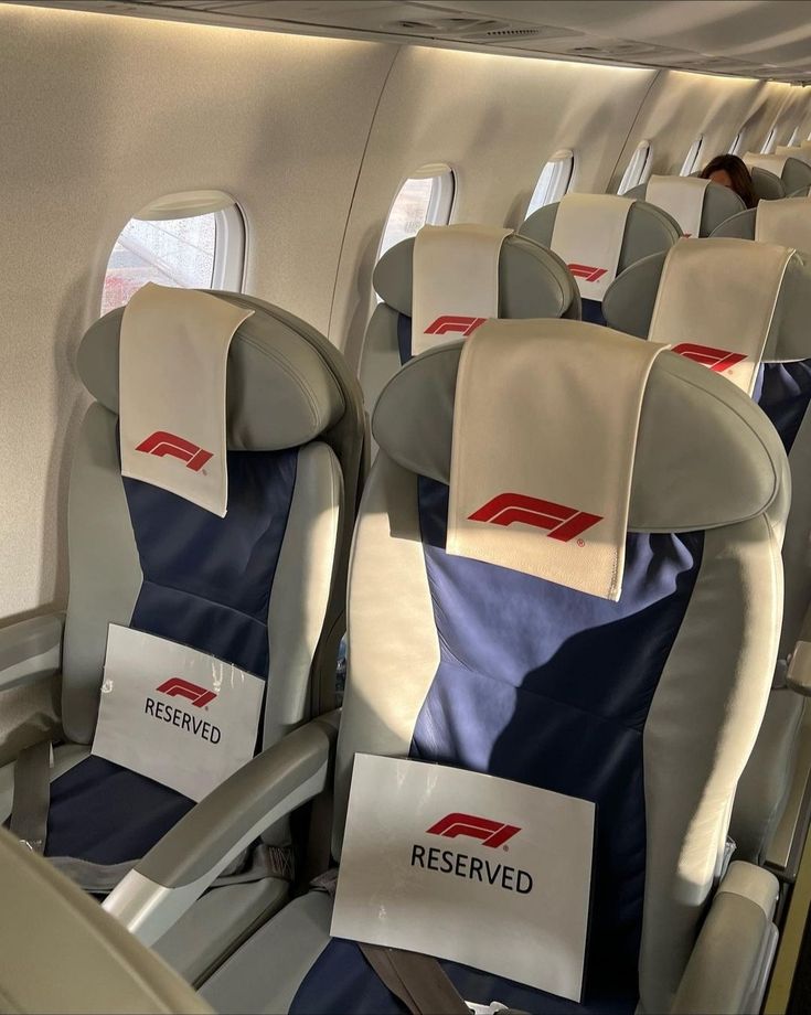 rows of empty seats on an airplane with reserved signs attached to the armrests