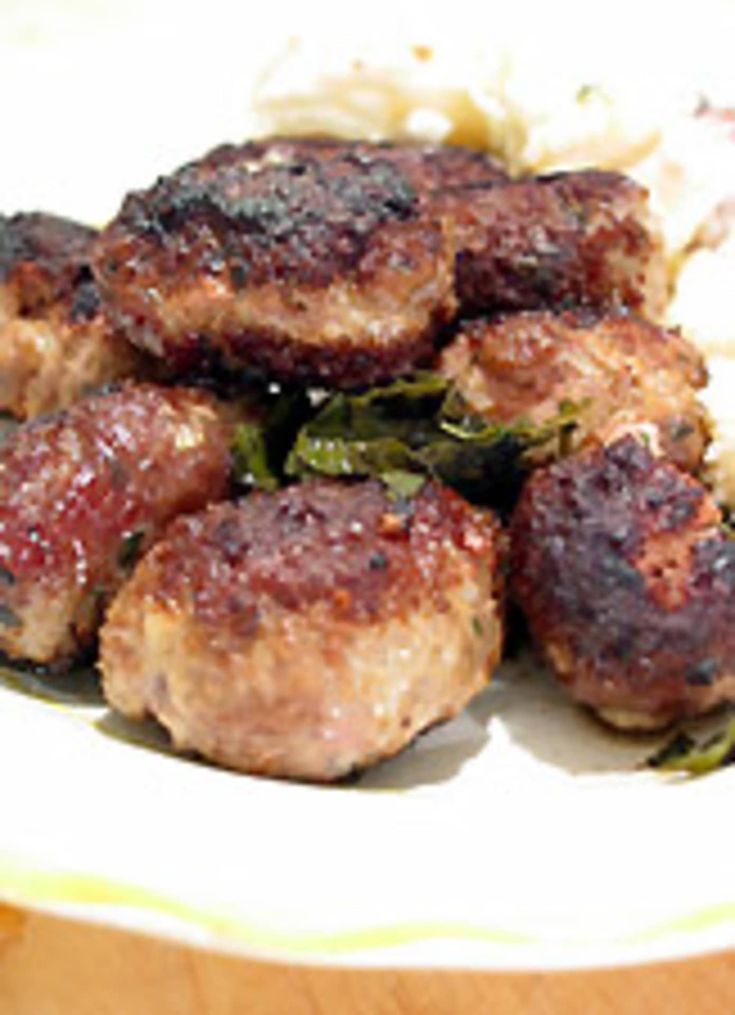 meatballs and vegetables on a plate with rice in the foreground, ready to be eaten