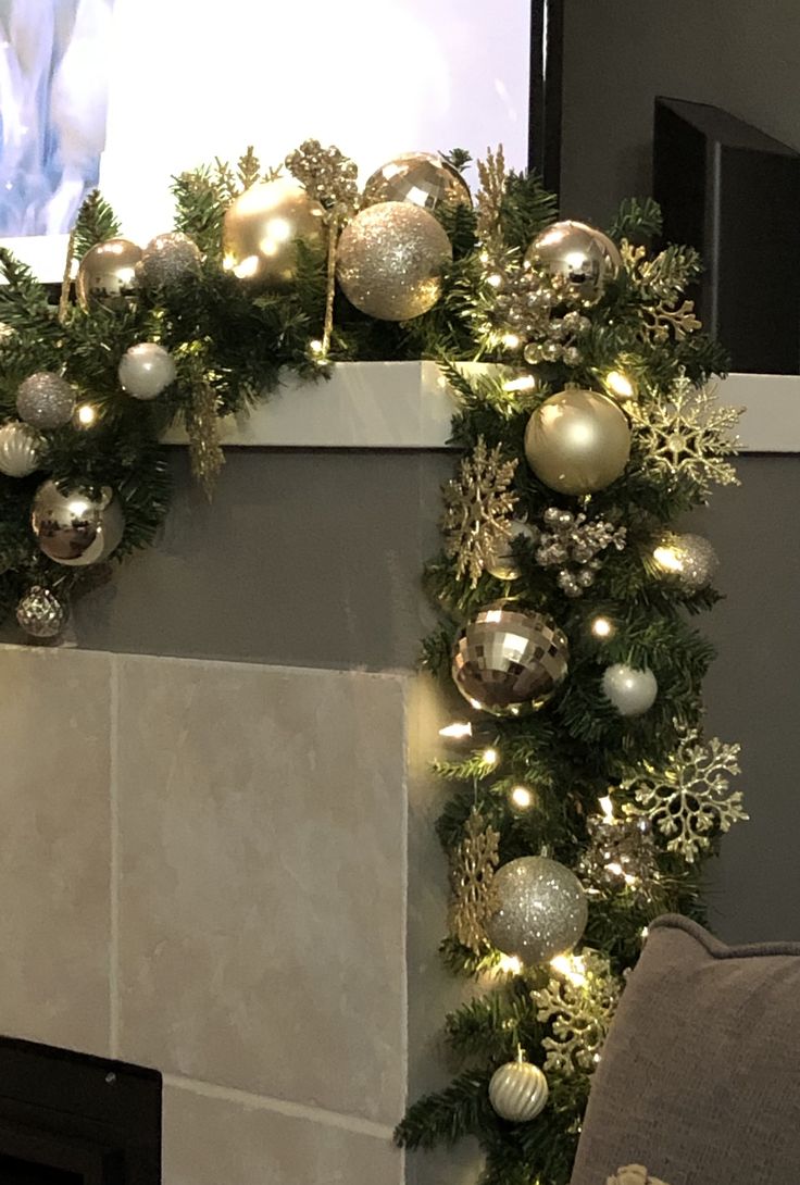 a fireplace decorated for christmas with ornaments and lights