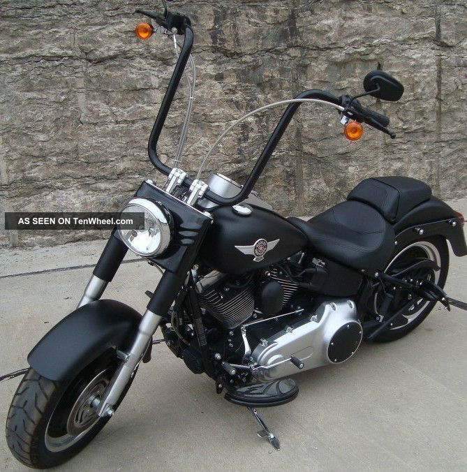 a black motorcycle parked in front of a stone wall