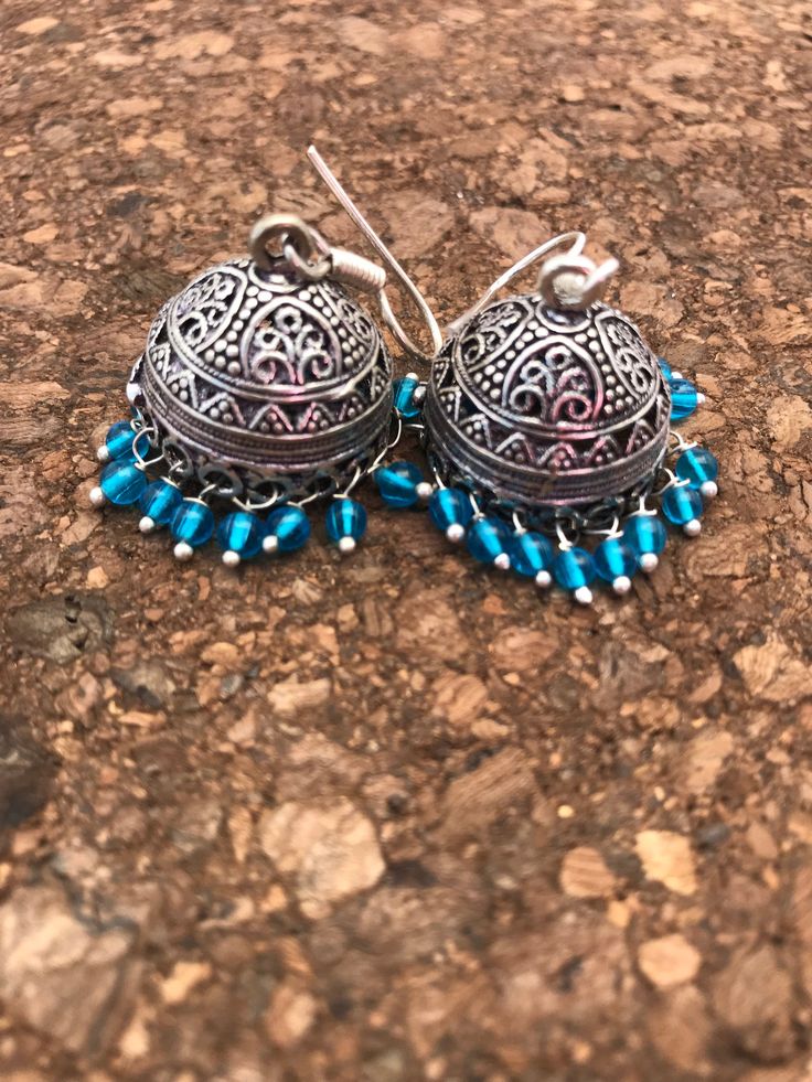 Jhumkas are the calling on the runway ramps this year. This is a traditional artist Jhumki handmade with love. Finished up with beautiful teal drops. A very hot pair for this season. I have made it again as I received many requests to do so. The length of the earrings is 2 inches from top to the tip of the earring. If you want unique this season then these are a pair you must own. Wear temple art and become a part of rich tradition. Thank you for your support Go back to Storefront Taneesijewelry Traditional Festive Earrings With Bells, Traditional Festive Bell Earrings, Festive Fusion Danglers For Navratri, Traditional Chandbali Jhumkas With Bells, Temple Jewelry Festival Earrings With Latkans, Fusion Style Danglers With Latkans For Navratri, Fusion Style Jhumkas With Latkans For Celebration, Fusion Style Chandbalis With Latkans For Navratri, Fusion Style Chandbalis With Latkans For Festivals