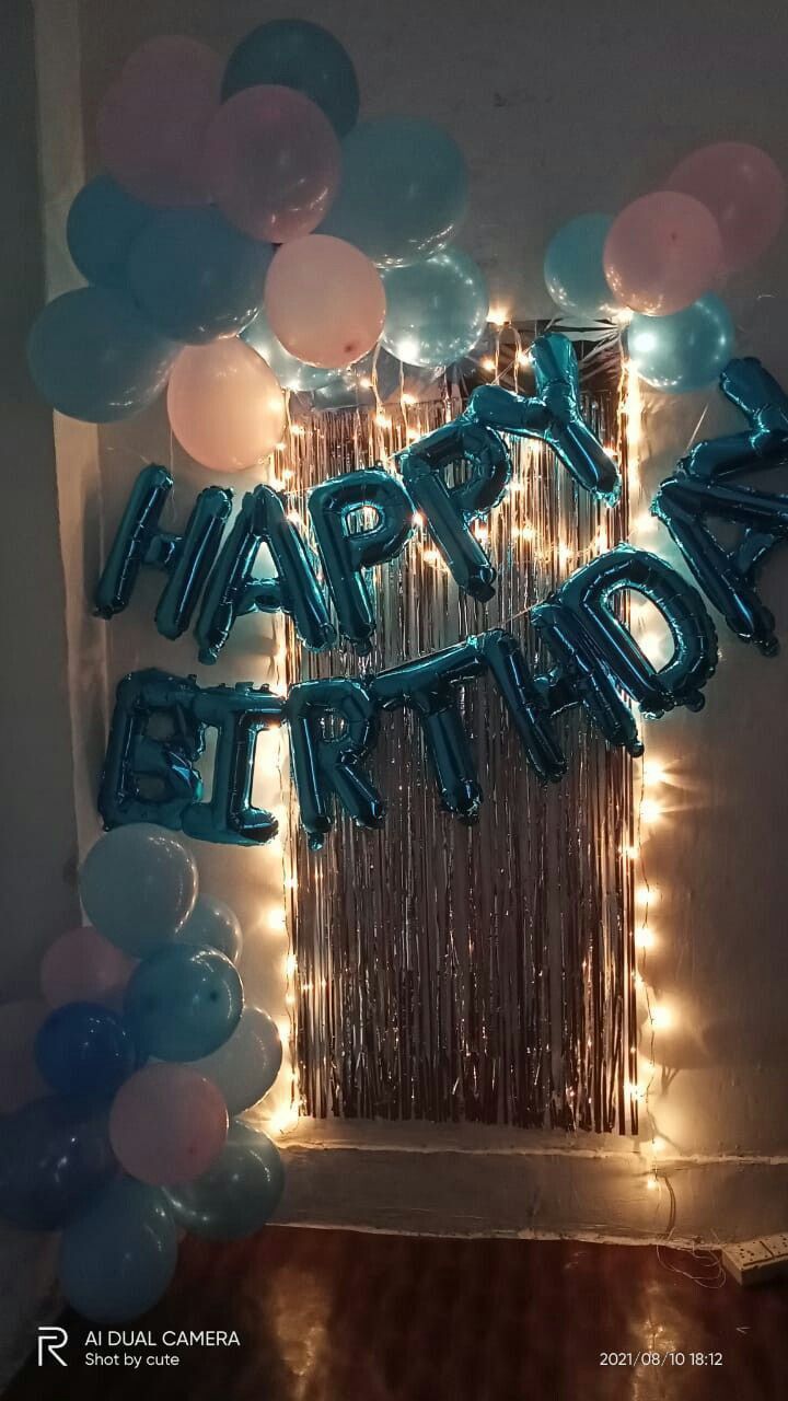 balloons and streamers with the words happy birthday written on them in front of a wall