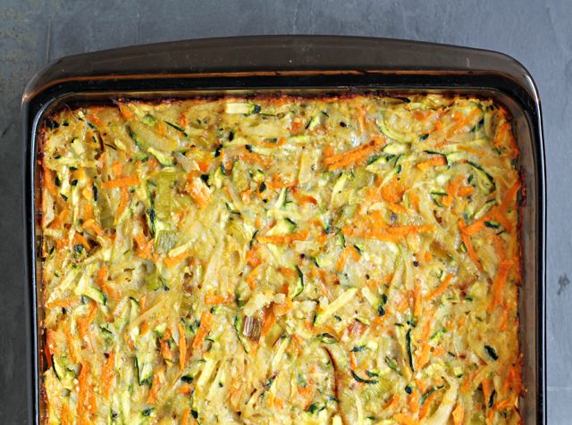 a casserole dish with carrots, zucchini and spinach in it