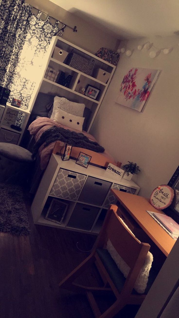 a bedroom with a bed, desk and bookcases in it's corner