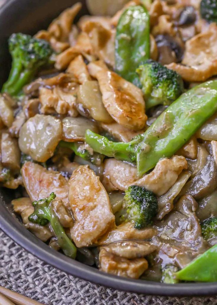 a bowl filled with chicken and broccoli on top of a table