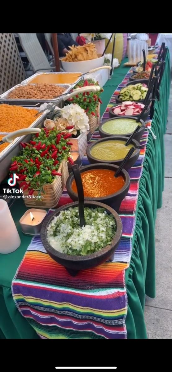 a long table filled with lots of different types of food on top of green cloths